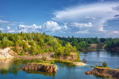 Kayalık kıyıları ve ormanı olan küçük bir göl.