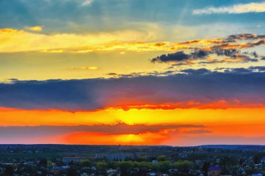 Şehrin üzerinde gün batımı, bulutlu gökyüzü..