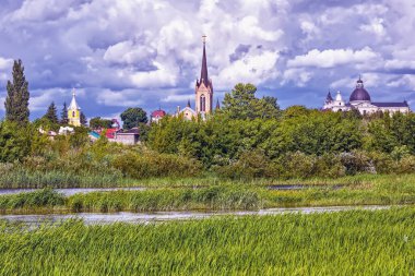Yaz manzarası - kiliseleri, tapınakları ve bulutlu bir günde parkı olan nehir kıyısı (Lutsk, Ukrayna).