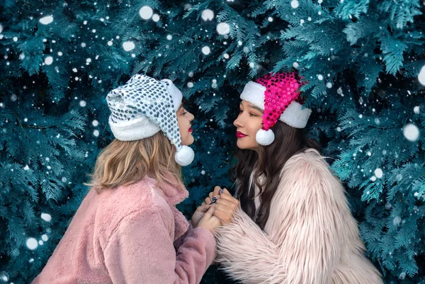 Dos Mujeres Jóvenes Con Sombrero Santa Sosteniendo Mano Aire Libre — Foto de Stock