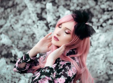 Parkta poz veren pembe saçlı genç bir kadının portresi. 