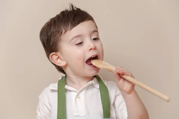 Kleiner Junge leckt Kochlöffel — Stockfoto