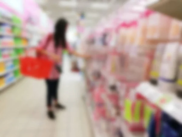 Mujer borrosa llevando una cesta mientras hace compras —  Fotos de Stock