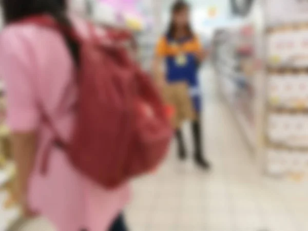 Mulher desfocada carregando uma cesta enquanto faz compras — Fotografia de Stock