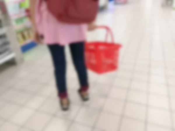 模糊的女人在购物时提着一篮 — 图库照片