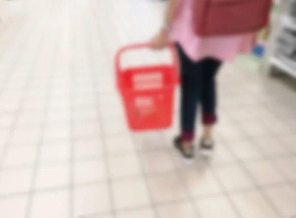 Mujer borrosa llevando una cesta mientras hace compras —  Fotos de Stock