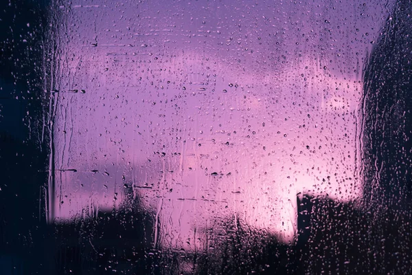 Mokre Błyszczące Szkło Okienne Kroplami Deszczu Widokiem Ulicę Zachodzie Słońca — Zdjęcie stockowe