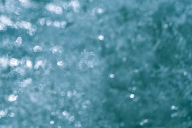 Bulanık açık mavi arkaplanda bir sürü beyaz, parlak, soyut nokta var.