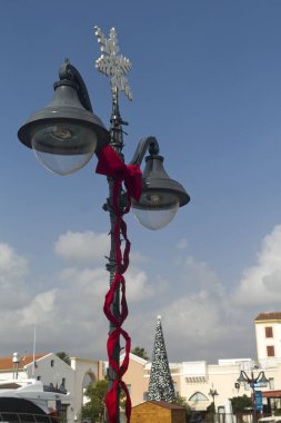 Limasol, Kıbrıs, 26 Kasım 2019: Limasol Marina 'da kırmızı Noel yayıyla süslenmiş sokak ışıkları