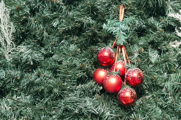 Ένα Μάτσο Κόκκινες Μπάλες Κρέμονται Στο Πράσινο Τεχνητό Χριστουγεννιάτικο Δέντρο — Φωτογραφία Αρχείου