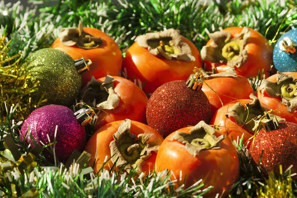 Πολύχρωμα Χριστουγεννιάτικα Μπιχλιμπίδια Και Ώριμα Φρούτα Από Λωρίδες Πορτοκαλιού Ξαπλωμένα — Φωτογραφία Αρχείου