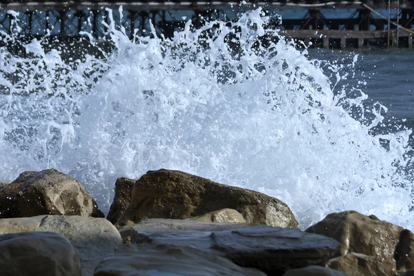 Onda Bianca Del Mare Spruzza Rocce Con Molo Uno Sfondo — Foto Stock