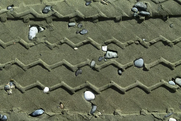 Close Van Verschillende Bandensporen Het Grijze Strandzand Met Kleine Stenen — Stockfoto