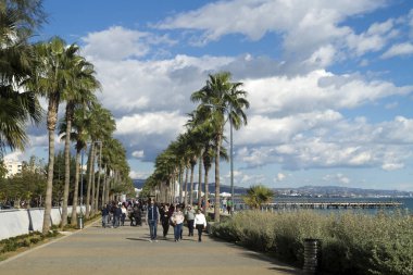 Limasol, Kıbrıs, 27 Aralık 2019: Molos yürüyen insanlarla ve güneşli bir kış gününde beyaz bulutlu mavi gökyüzüyle geziniyor