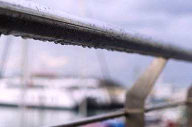 Yağmur damlaları ve bulanık arkaplan ile köprü çiti