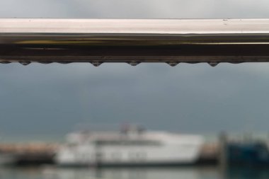 Arkaplanı bulanık metal çitlerde yağmur damlaları