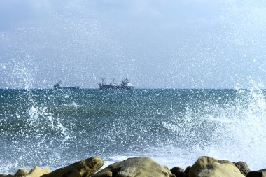 Ufukta beyaz dalga arka planında gemiler olan deniz manzarası