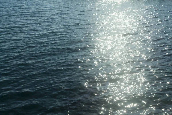 Rippled blue sea water surface with sun sparkles