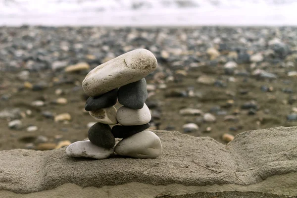 Zen-like stone pyramid standing on a rock at the sea beach