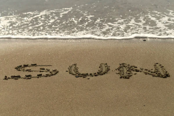 Slovo Slunce Napsané Mokrém Písku Pláži Lesklou Pěnovou Vlnou — Stock fotografie