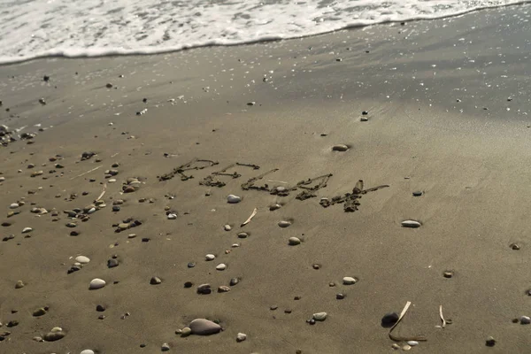 言葉で海のビーチ湿った砂の上に書かれたリラックス — ストック写真