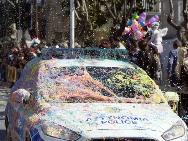 Police car sprayed with colorful silly strings moving along the street during the Grand Carnival Parade in Limassol, Cyprus