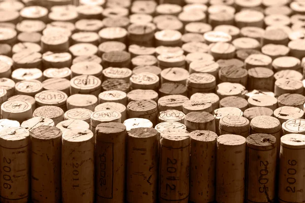 Selection of used natural wine corks, some of them marked with years of vintage, monochrome brown