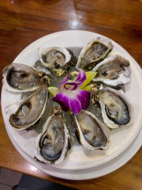 Orkide çiçekli ve limonlu taze istiridye.