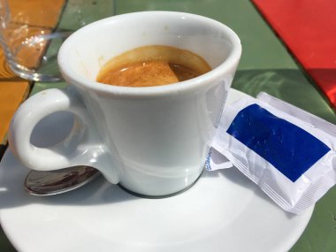 Bir fincan sade kahve espresso ve şeker kesesi.