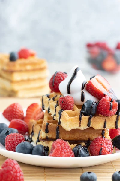Tahta arka planda taze meyveli Belçika waffle 'ları.