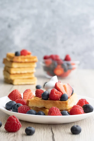 Tahta arka planda taze meyveli Belçika waffle 'ları.