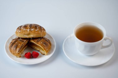 Ahududulu zencefilli kurabiye ve beyaz bir terasta çay.