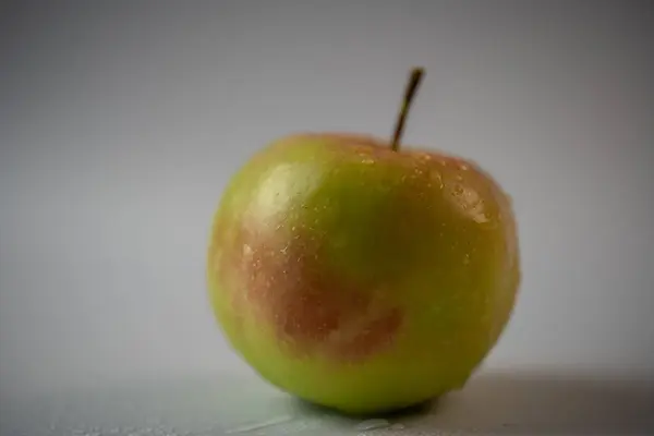 Pomme avec des gouttes d'eau sur fond blanc — Photo