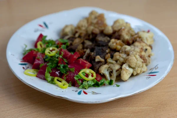 Tasty lunch on a plate. Fried meat slices, cauliflower, hot pepp — Stock Photo, Image