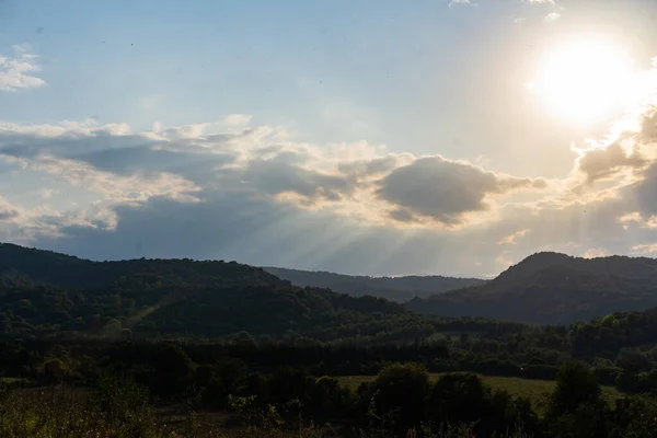 Солнечные лучи светят сквозь облака в горах . — стоковое фото