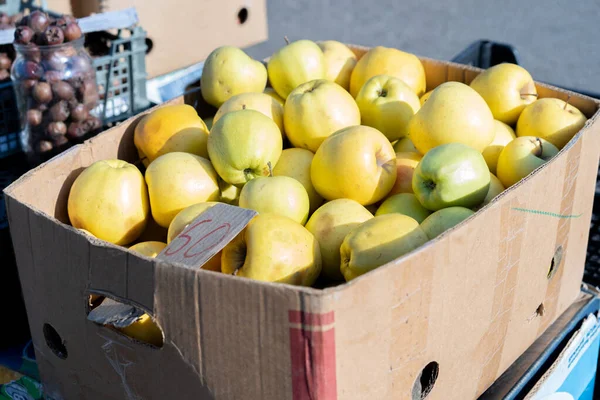 Желтые яблоки на продажу в коробке — стоковое фото