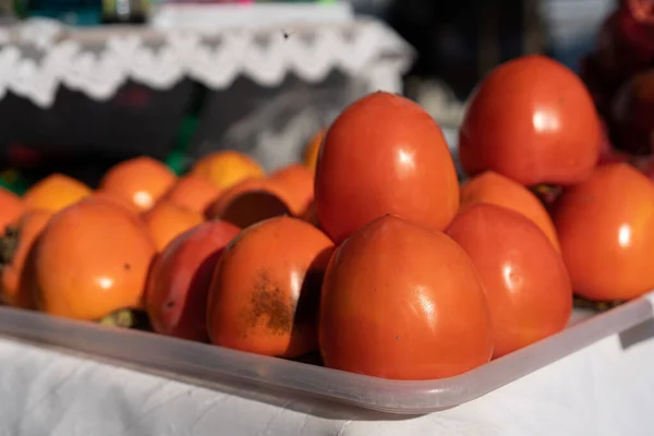 Persimmons on a counter for sale — Stock Photo, Image