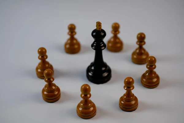 Piezas de ajedrez, rey negro rodeado de peones blancos — Foto de Stock