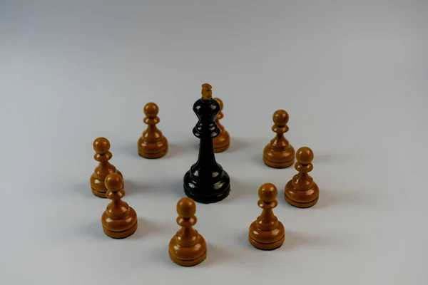 チェスの駒、白い駒に囲まれた黒い王 — ストック写真