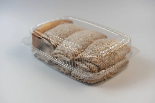 Deliciosos pasteles están en envases de plástico, sobre un fondo blanco — Foto de Stock