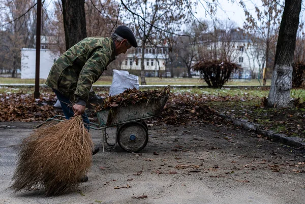 Janitor sweeping a broom yard