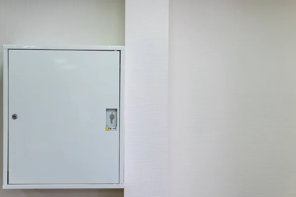 Duvardaki metal bir kutuda yangın hortumu.