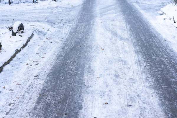 Śliska zamarznięta droga z lodem i śniegiem — Zdjęcie stockowe