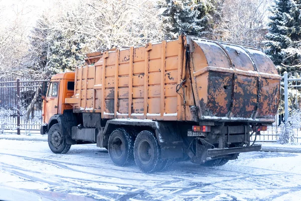 Апельсиновая машина собирает мусор в зимний сезон — стоковое фото