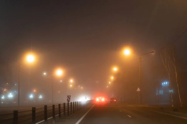 Auta jezdí v noci v mlze — Stock fotografie