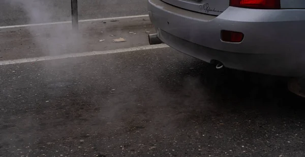 Yolda duran bir arabanın egzoz dumanı.