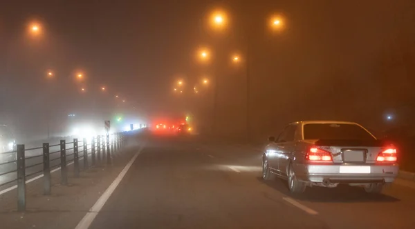 Bilar rider i dimman på natten — Stockfoto