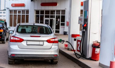 Benzin istasyonundaki bir hortumdan makineyi dolduruyorum.