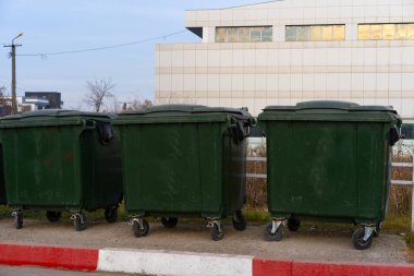 Kapalı yeşil tekerlekli çöp kutuları
