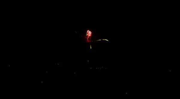 Fogos de artifício à noite em um fundo de céu preto — Fotografia de Stock